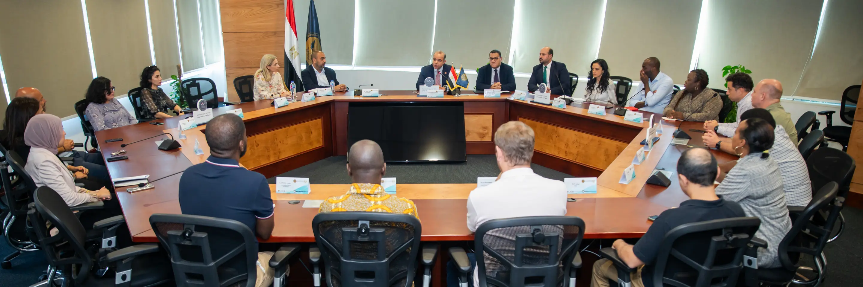 Group of people sitting around a circular table at a meeting