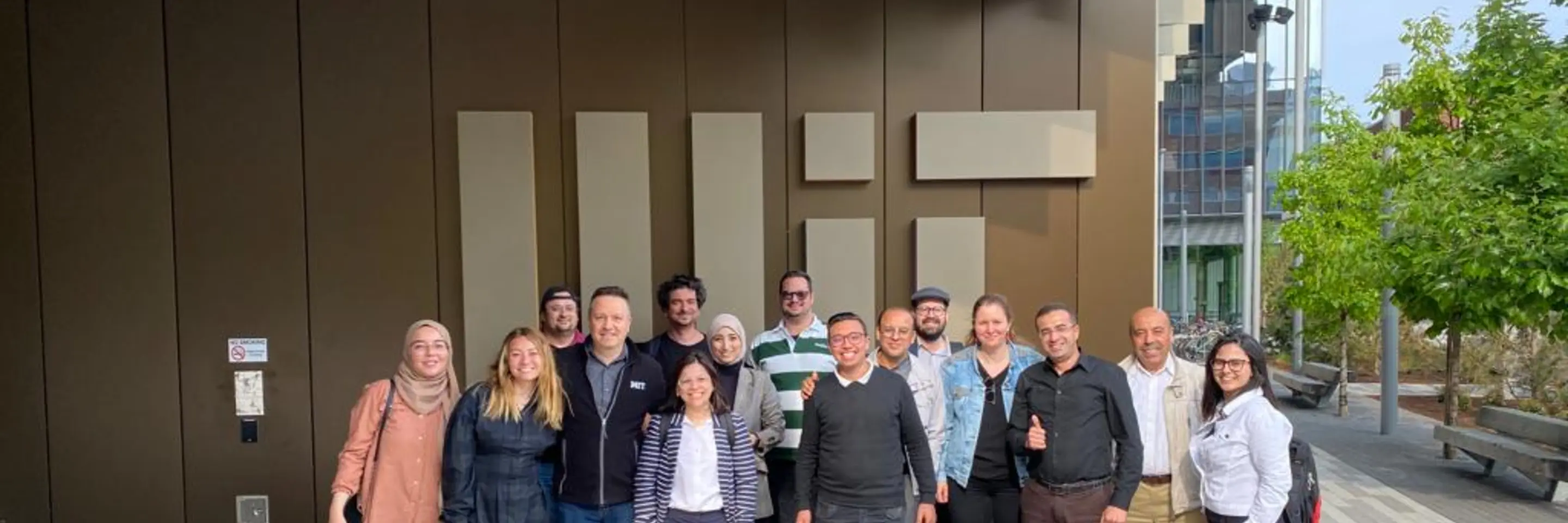 Group of entrepreneurs outside in front of an MIT logo