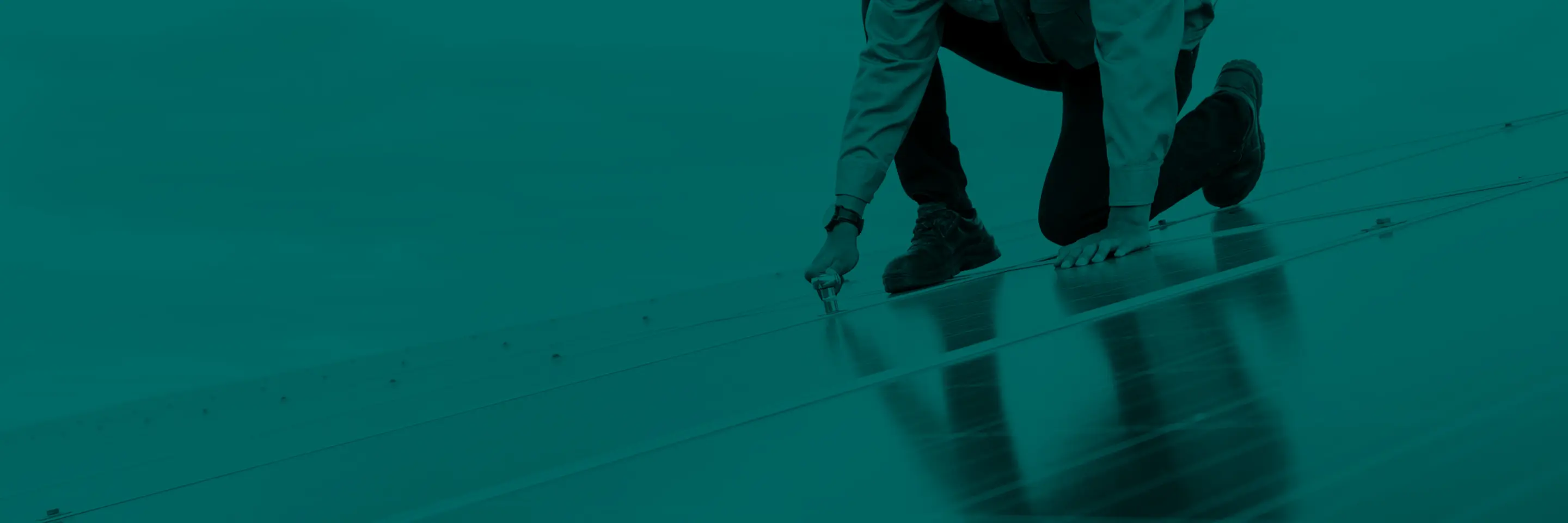 Colored image of worker standing atop solar panel