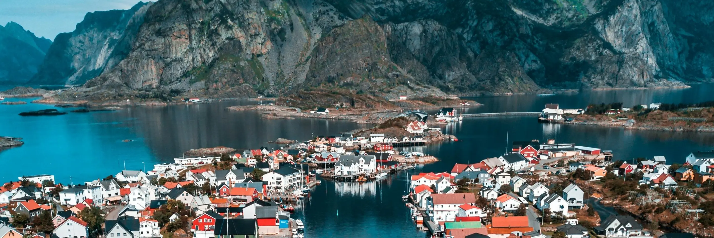 Image of a Norwegian town with mountains in the background