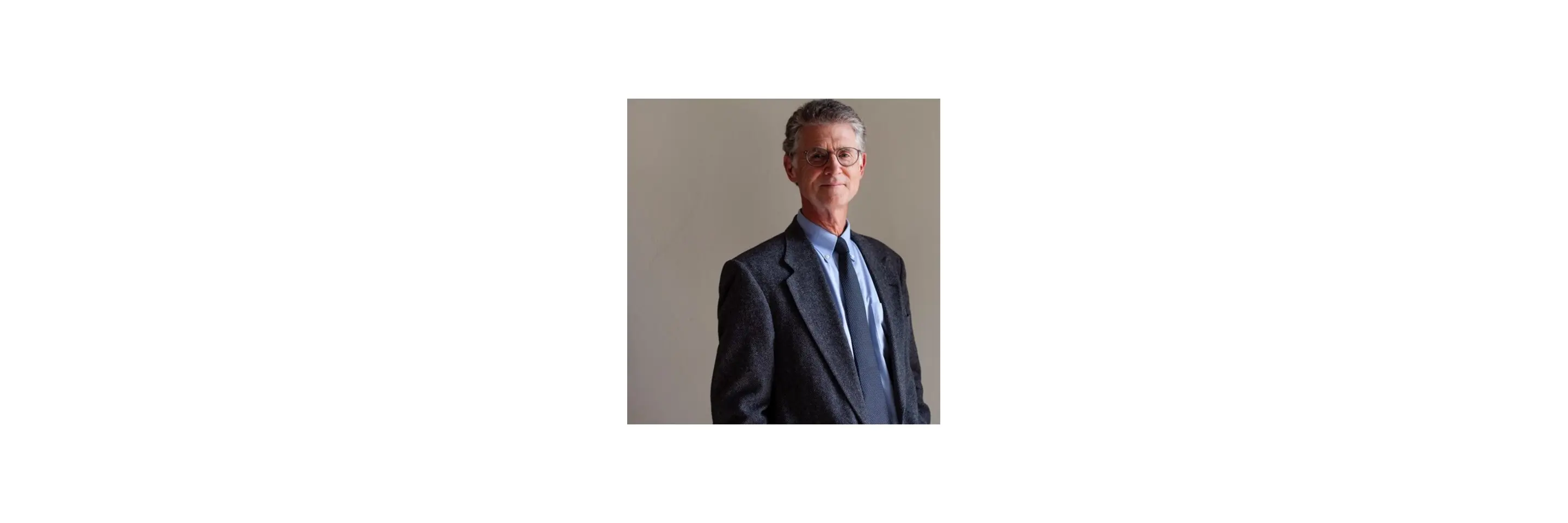 Photo of Peter R. Fisher (white man with gray hair and glasses wearing a business suit