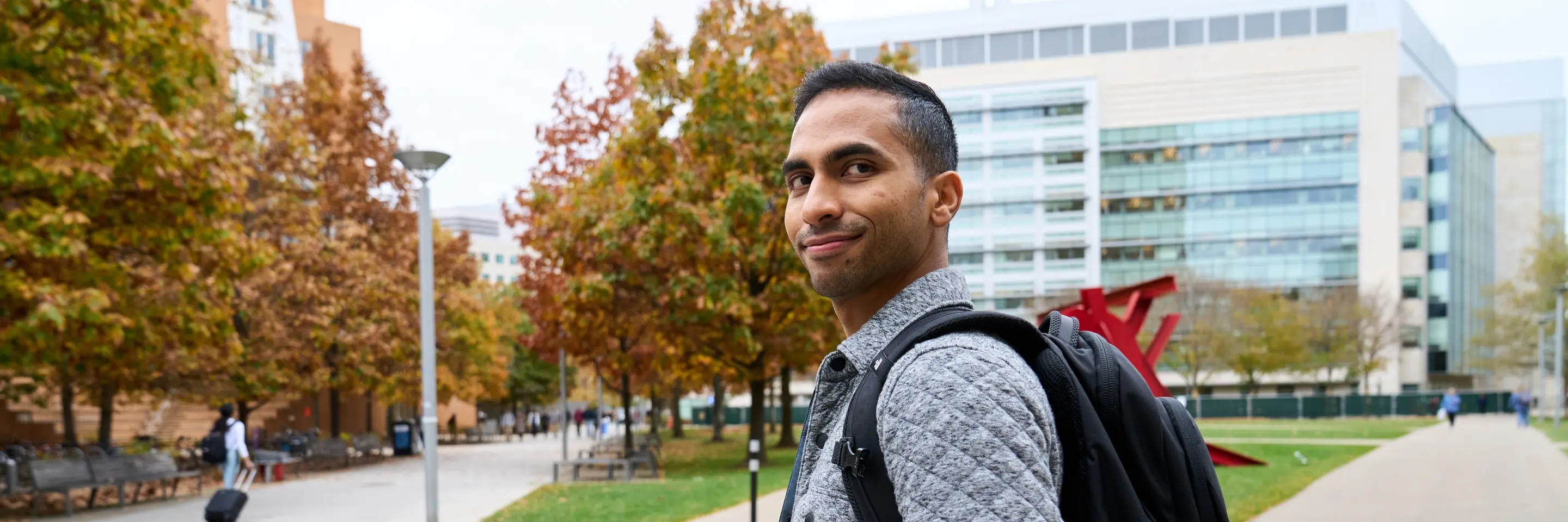 LGO student Abhi Rao walks through MIT's campus