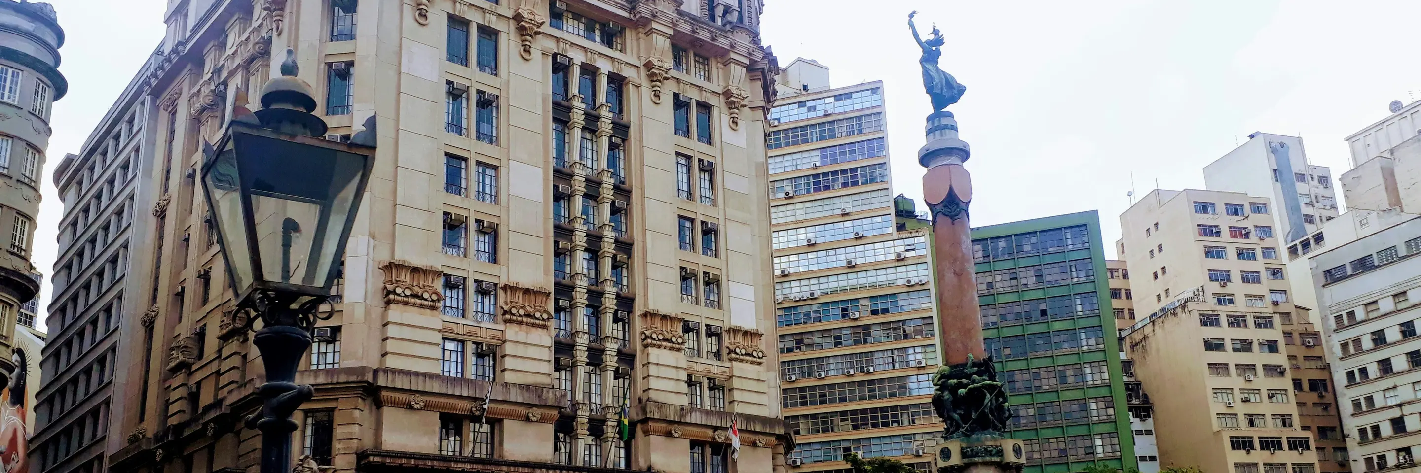 A tall building with a statue in front of it. 