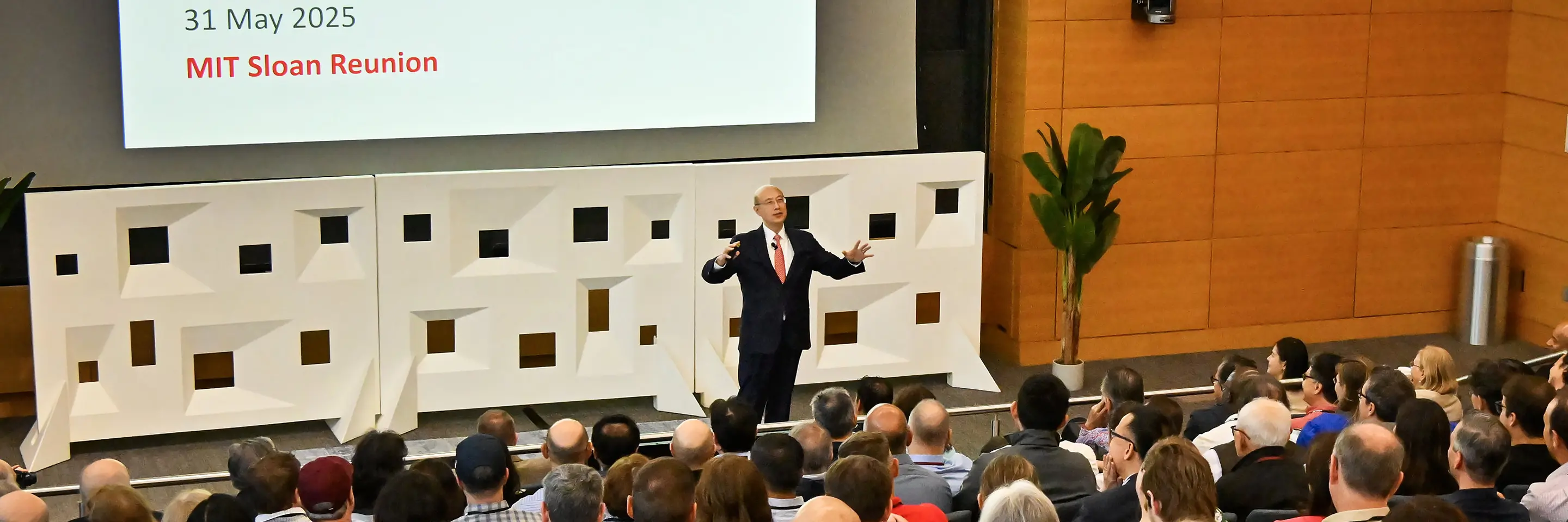 A person delivers a lecture to a crowded auditorium
