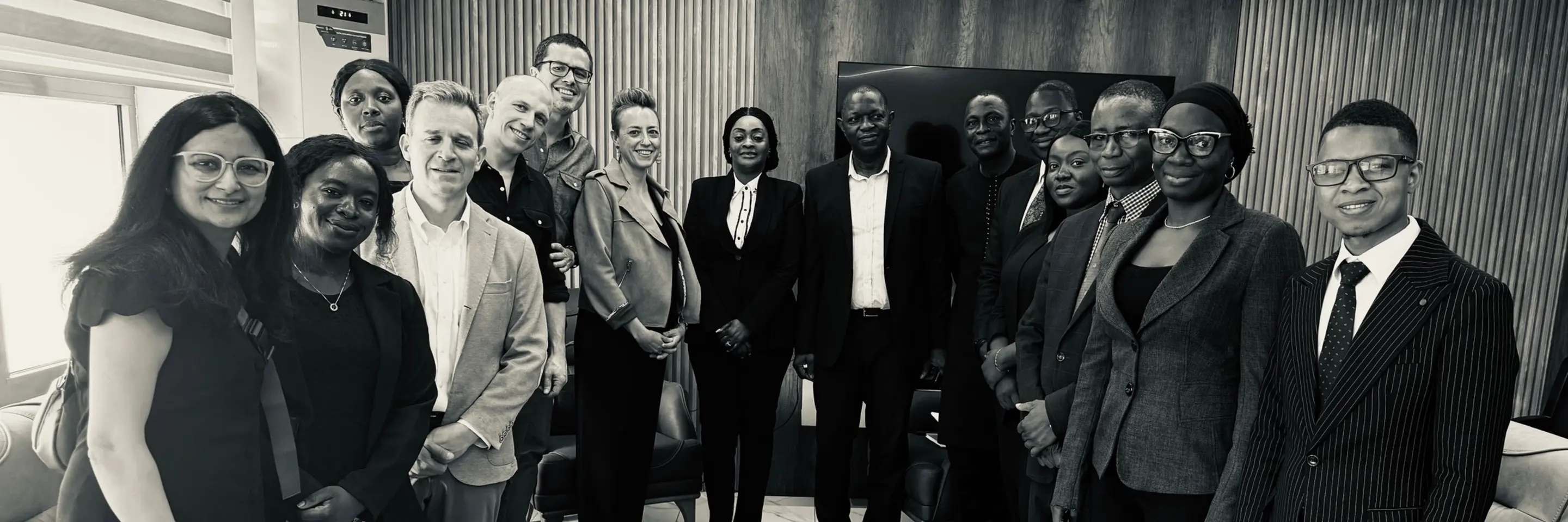 A group of fifteen people pose for a photo. Among them are Adam Cohen, Owen Dempsey, Ross Beyeler, and Rama Kataria, the MIT Sloan EMBA students who worked on the Reignite the Streets project