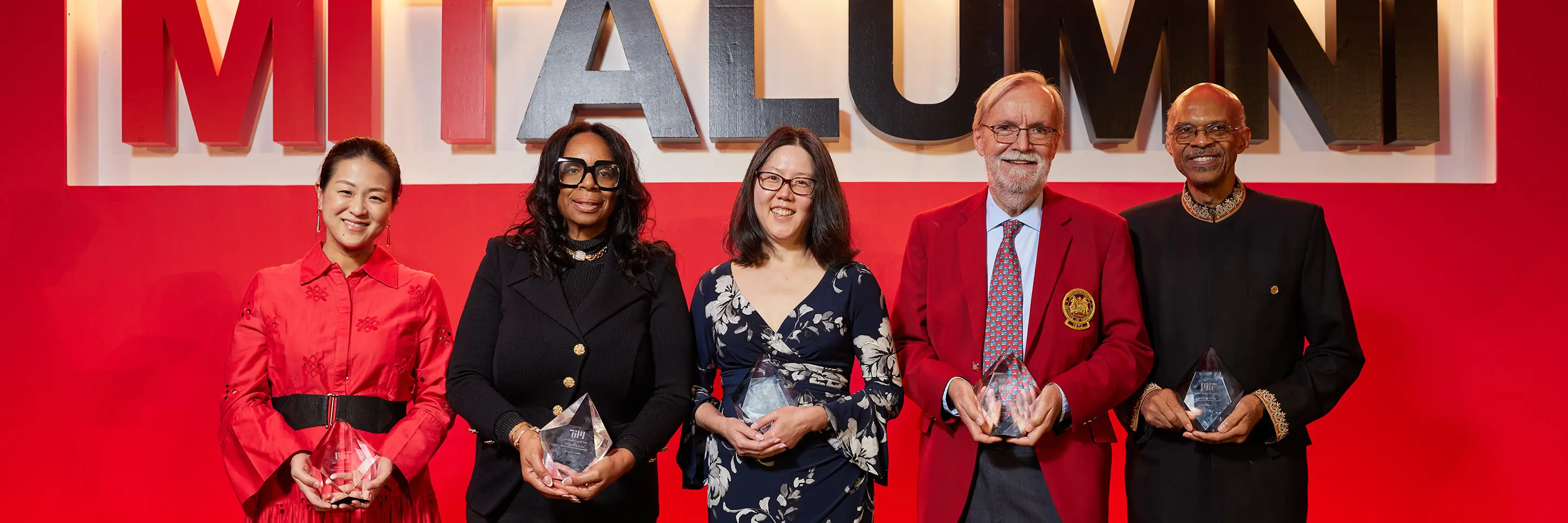Group of people stands on stage holding awards