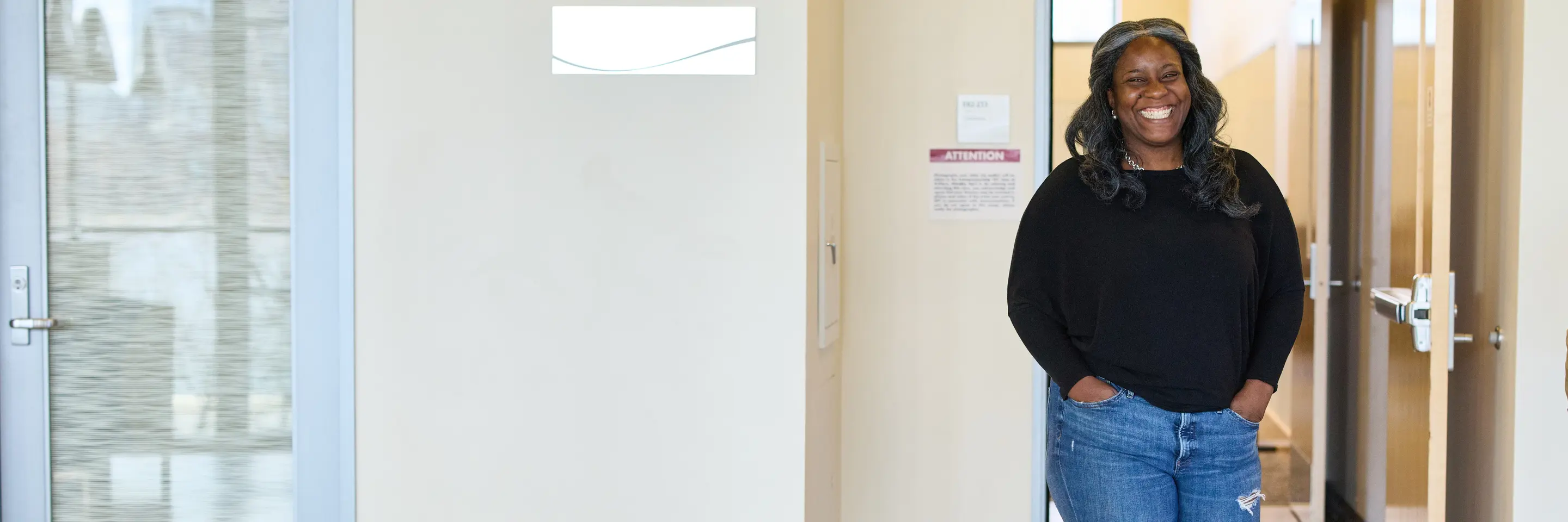 Alecia Asiamigbe walks through the halls of MIT Sloan, smiling at the camera