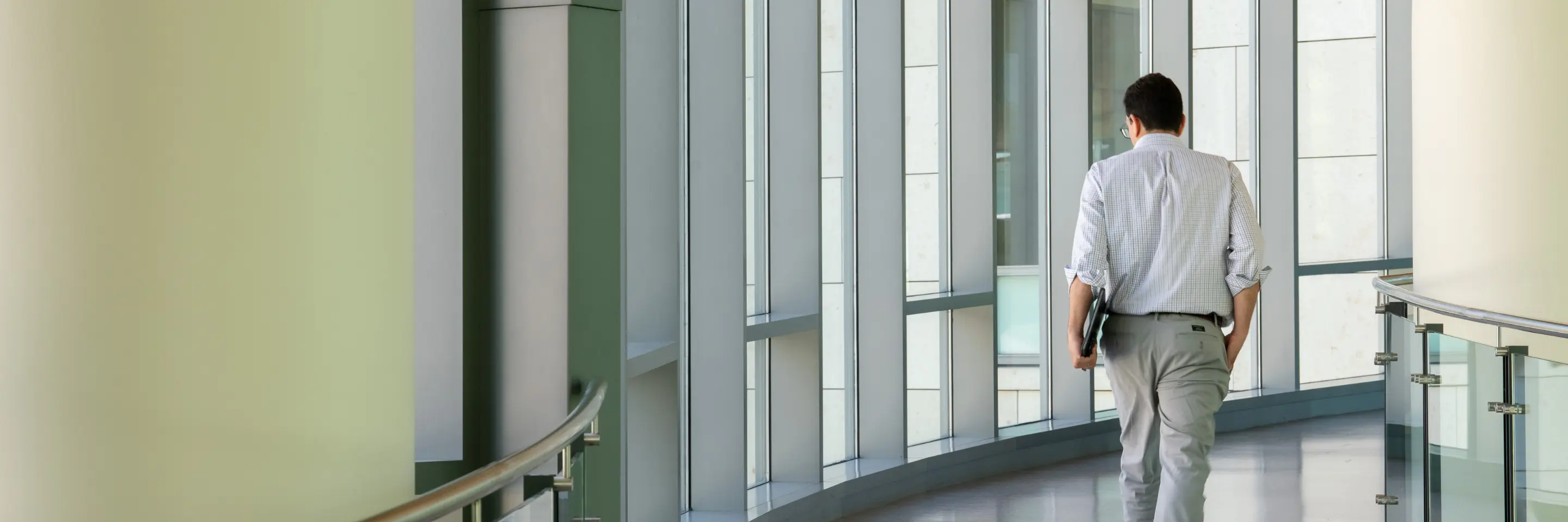 Man walking on the indoor bridge connecting building E62 with E52.