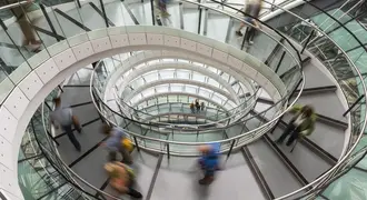 Photograph of a circular staircase and people quickly moving up and down