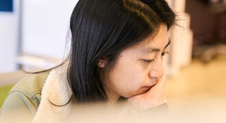 Megan Hung looks down with her head in her hands.