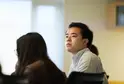 Patrick Yeung sits in a conference room with other students. He looks intently at something outside the frame