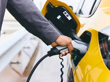 Hand plugging a charger in EV