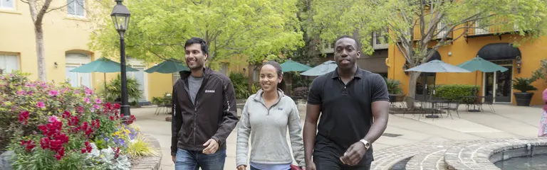 3 USA Lab students walking along a sidewalk in Charleston, SC. 