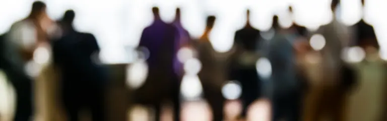 Blurred group of people standing.