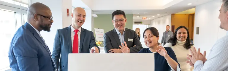 EMBA students reviewing a presentation idea at an easel pad.
