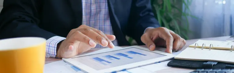 Man in suit looking at graphs on iPad