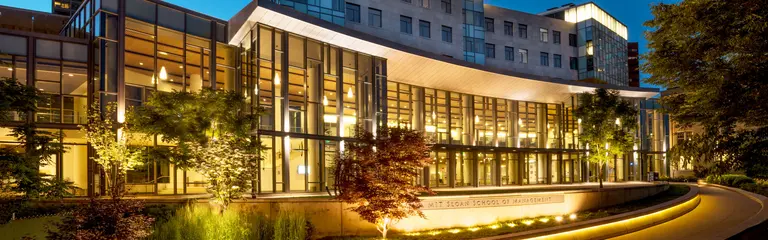 River side of MIT Sloan Building E62 at dusk