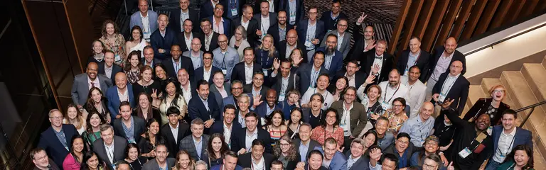 A large group of people pose for a photo at the bottom of a staircase