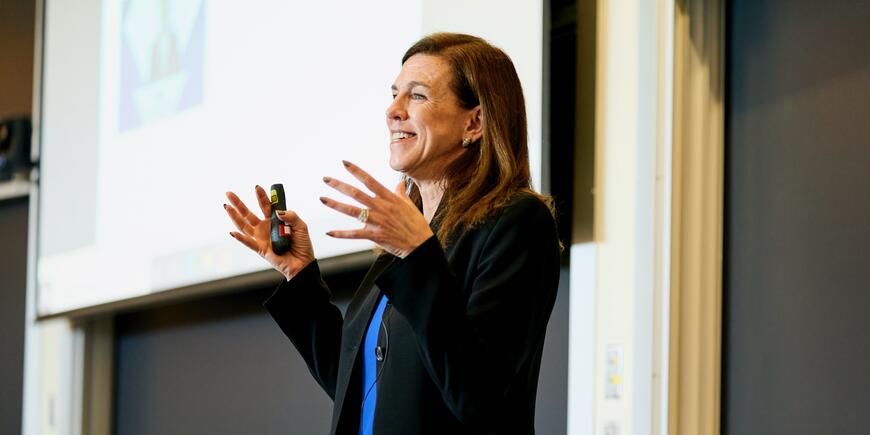 Professor Kristin Forbes giving a lecture, she's smiling