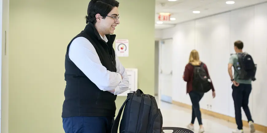 Sandro standing with his arms crossed, turned to the right