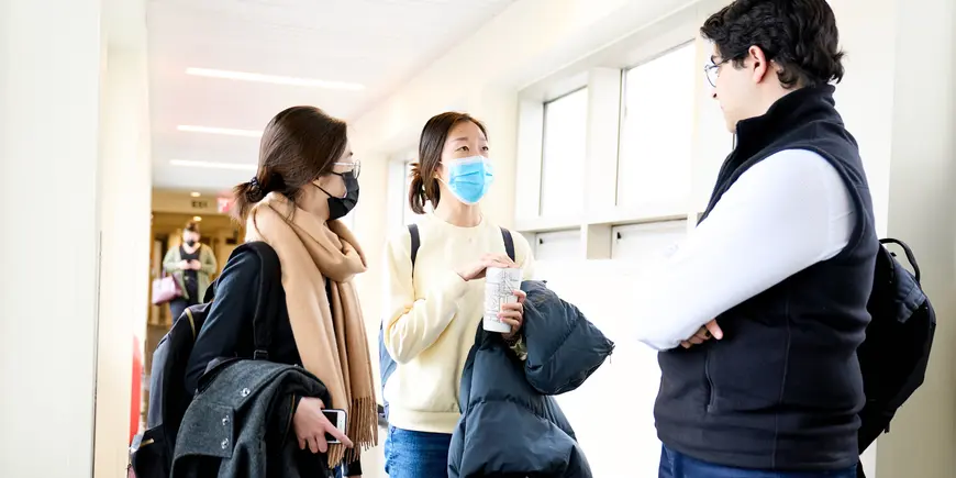 Betty, Haiyi, and Sandro talking in a hallway