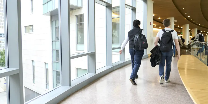 Sandro and another student walking through the building