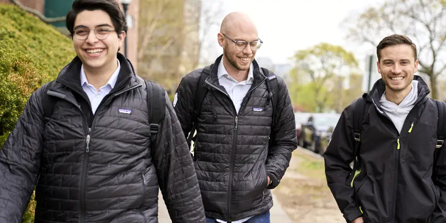 Sandro, Patrick, and Vlad walking down the street dressed in coats