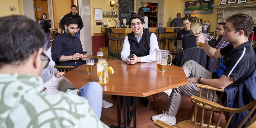 Sandro and others sitting at a table at the Muddy Charles