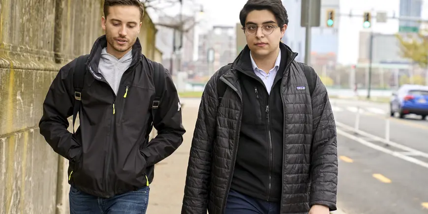 Sandro and Vlad walking down the street in coats