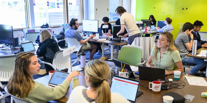 People sit together in several groups discussing topics