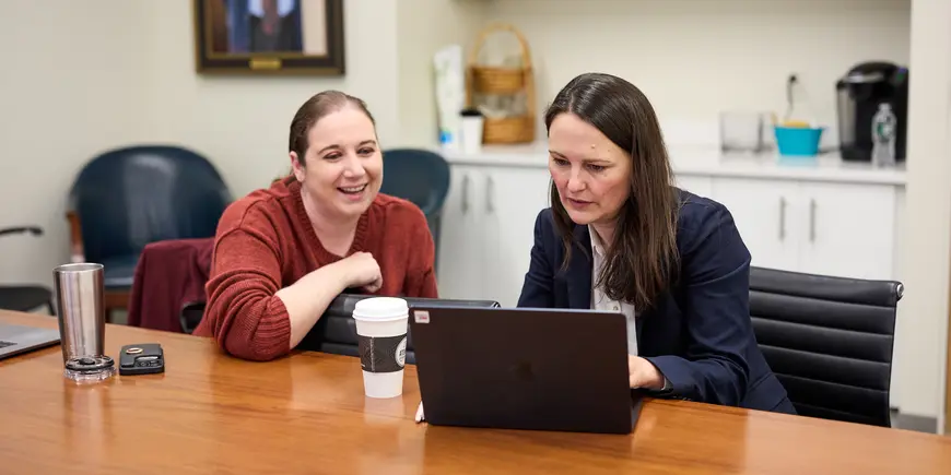 Jocelyn, a student, meets with an advisor in the program office.