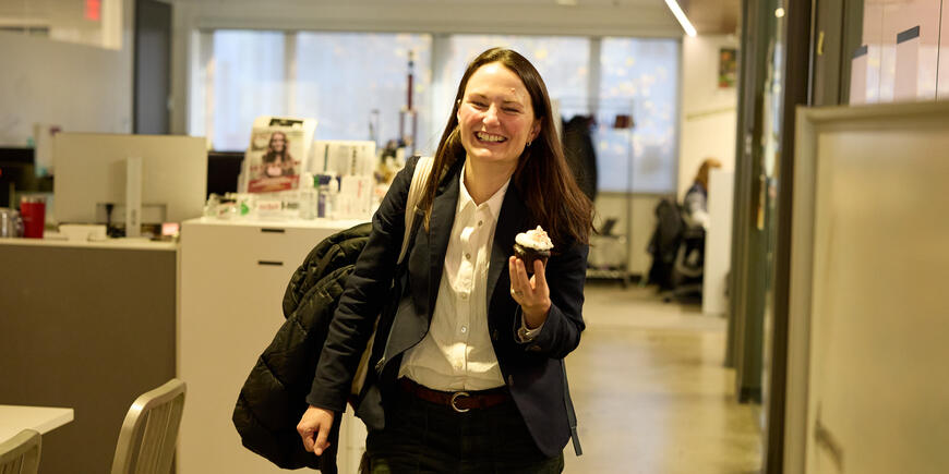 Jocelyn, a student, leaves with a cupcake in her hand.