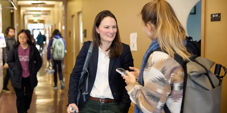 Jocelyn, a student, chats with her friend outside of the classroom.