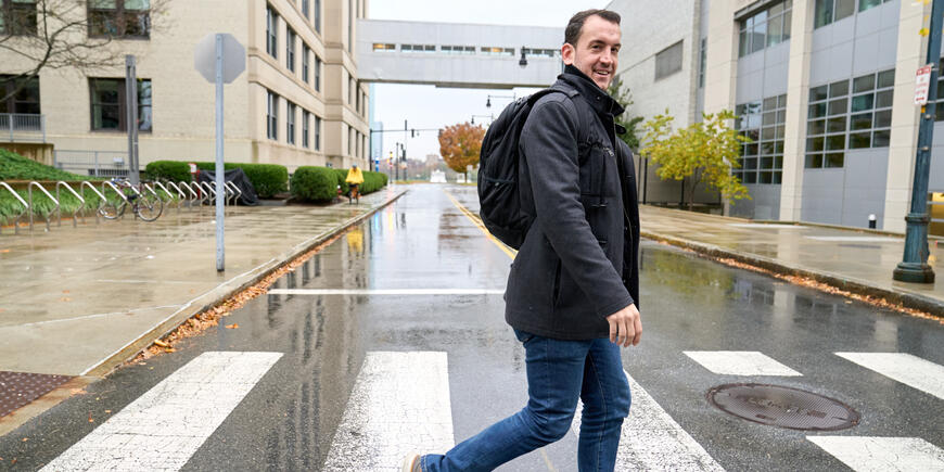 Jack O'Brien, a student, crosses the street as he heads to class at MIT Sloan.
