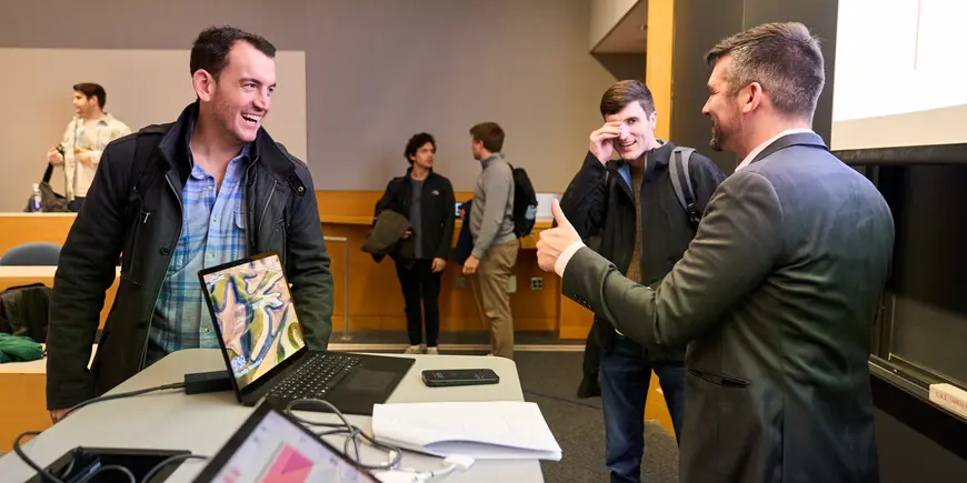 Jack O'Brien, a student, talks with another student and their professor in class.