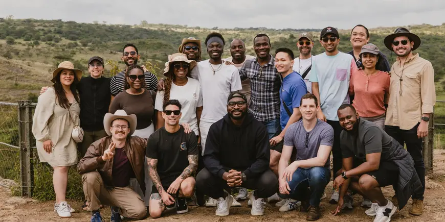 Large outdoor group photo with three rows of people