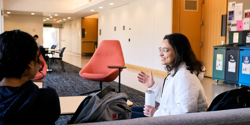 Khushi Pathak talks with a friend outside of a classroom.