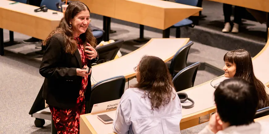 Professor Debbie Lucas talks with students before class.