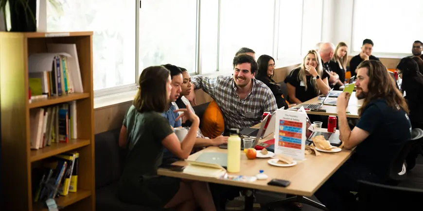 MIT Program participants sitting at a table working