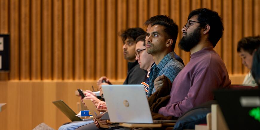 LGO student Abhi Rao sits in a lecture hall listening to a professor. 