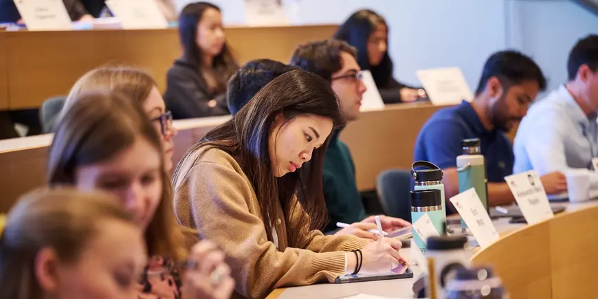 MBA student Sharon Fan takes notes while attending class. 