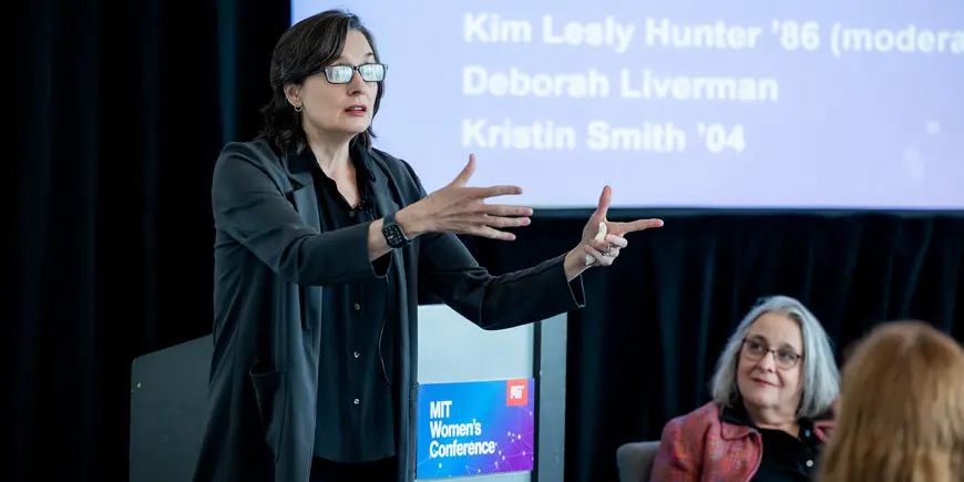 Woman gestures while speaking to audience