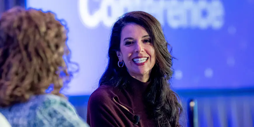 Smiling woman listens to speaker at event