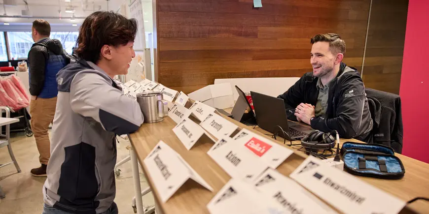 David Brown sits at a large desk in the Trust Center. He is talking to another person on the other side of the desk