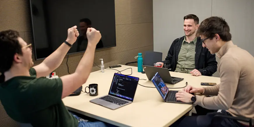 David Brown sits with two other people at a table in a small conference room. 