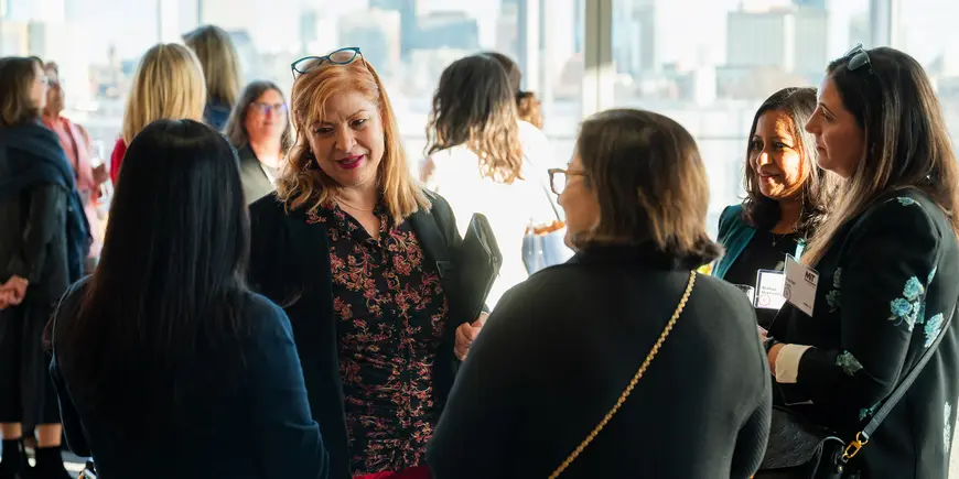 Group of women speaking in front of city skyline