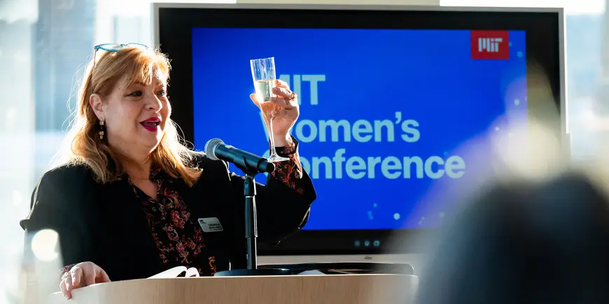 Woman raises glass to toast at event