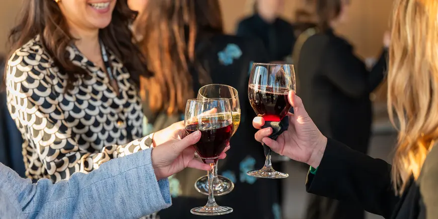Group of women raise their glasses in toast