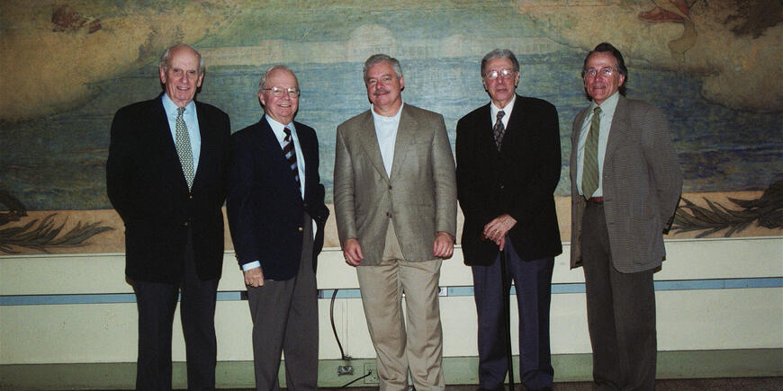 Five men pose for a photo