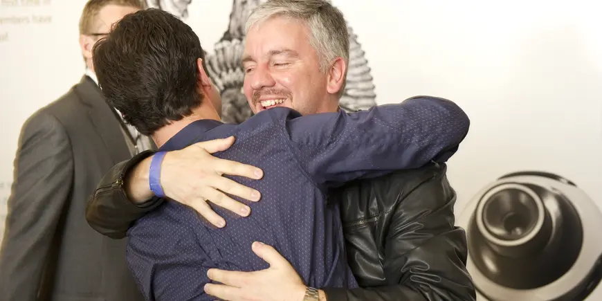 Two men embrace